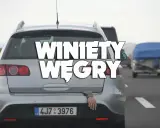 Srebrne kombi na autostradzie, z bagażnika wystaje ręka. Napis "Winiety Węgry" sugeruje podróż.