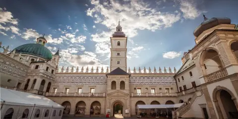 Piękny dziedziniec zamku Krasiczyn zachęca do zwiedzania. Architektura zachwyca pod błękitnym niebem.