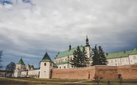 Klasztor Bernardynów w Leżajsku, jedna z głównych atrakcji miasta, z zielonymi dachami i ceglanym murem.