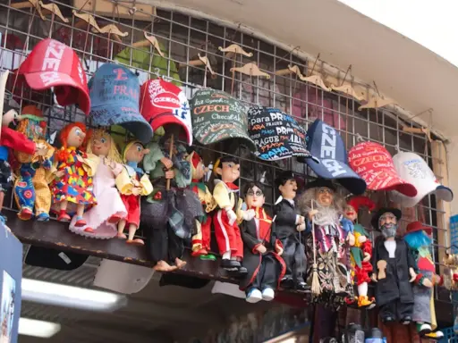 Lalki i czapki z napisami "Czechy" i "Praga" wiszą na straganie. Zastanawiasz się, ile kosztują pamiątki w Czechach?