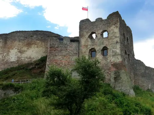 Ruiny zamku w Czorsztynie, z polską flagą na wieży. Warto kupić zamek w Czorsztynie bilety i zwiedzić to miejsce.
