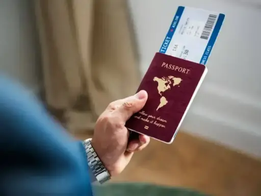 Dłoń trzyma paszport i bilet lotniczy. Czy na Cypr potrzebny jest paszport? Sprawdź przed podróżą!