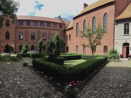 Dziedziniec zamkowy w Solcu Kujawskim, z zadbanymi żywopłotami i brukowanymi alejkami, to jedna z urokliwych atrakcji tego miejsca.