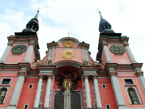 Święta Lipka: barokowa bazylika z zegarami na wieżach i złotymi symbolami religijnymi. Atrakcje tego miejsca przyciągają turystów.