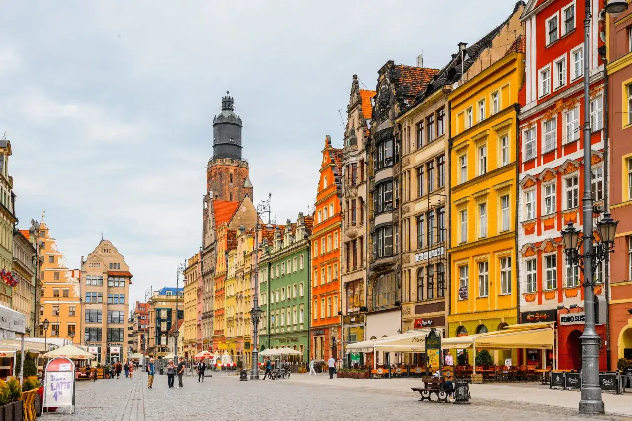 Kolorowe kamienice i wieża ratuszowa na starym rynku we Wrocławiu.